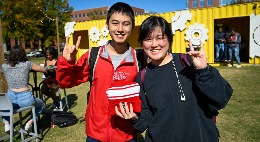 Two students show their NC State pride on campus