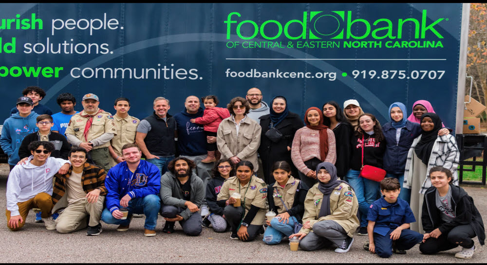 Volunteers posing in front of a Food Bank of Central and Eastern North Carolina donation trailer
