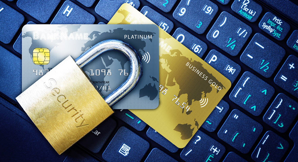 A padlock and two credit cards sitting on top of a computer keyboard