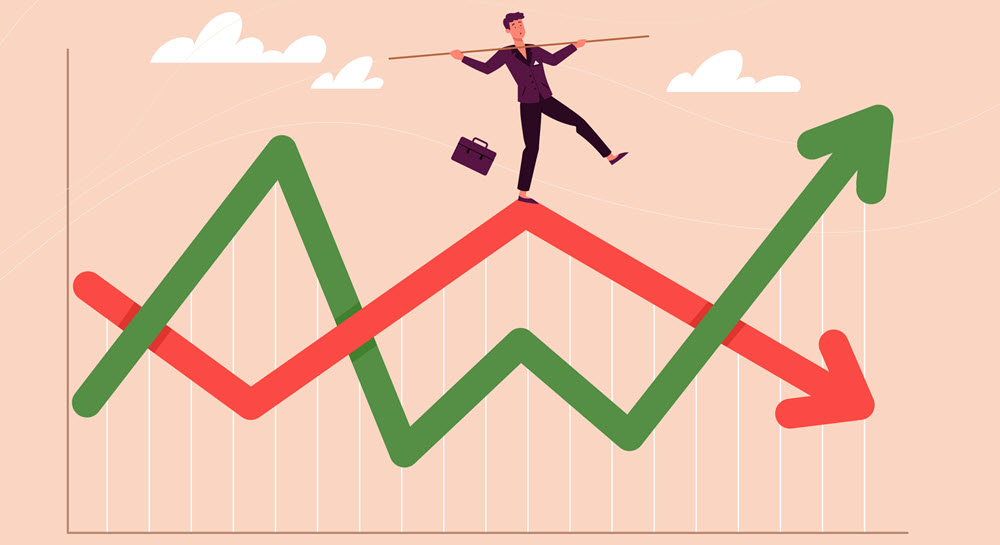 A businessman walking on a line graph as though it is a tight rope