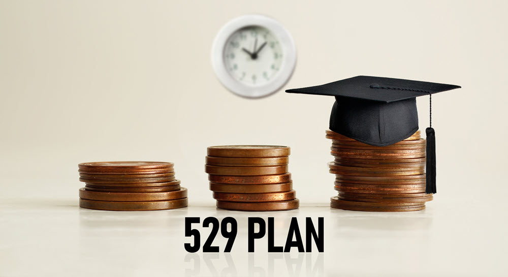 Three stacks of copper coins with a graduation cap on the third stack of coins and the words "529 Plan" written below.