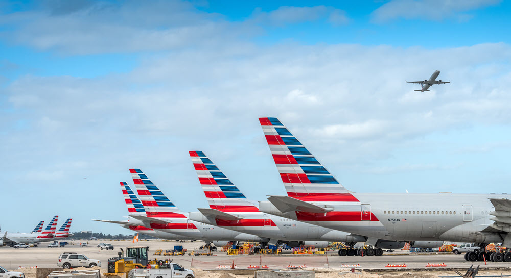 Planes with American flag tail graphics lined up at the airport