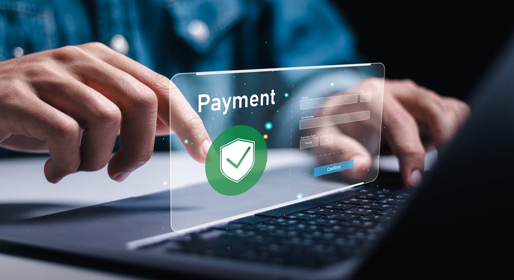 Hands typing on a laptop keyboard with a payment screen image in the center