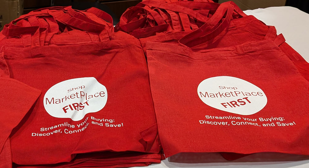 A stack of tote bags featuring the "Shop MarketPlace First" logo