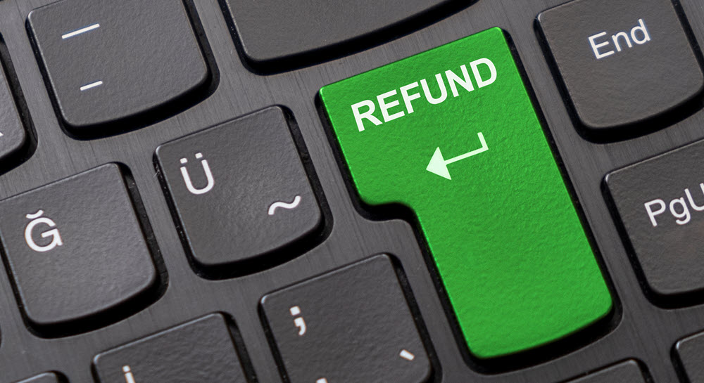 A computer keyboard with a large green "Refund" key in the place of the Enter key.
