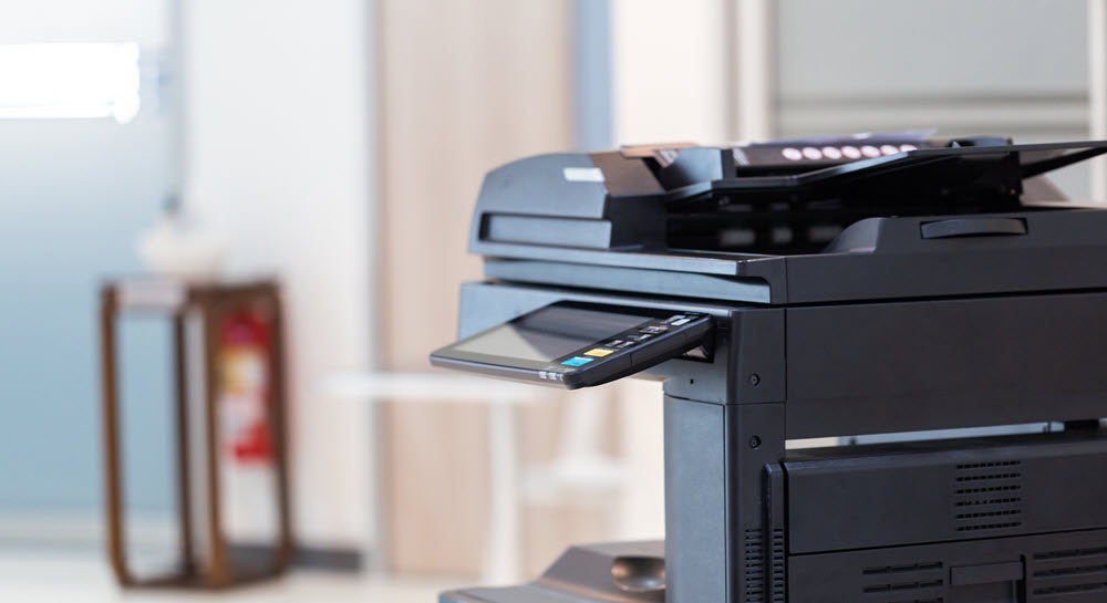 A black, multifunction copy machine in an office