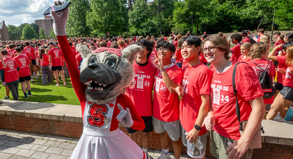 Students in orientation take a selfie with Mrs. Wuf.